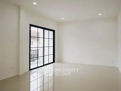 Spacious empty living room with large windows and glossy tiled floor