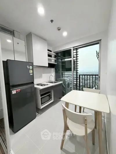 Modern compact kitchen with city view and dining area in high-rise apartment