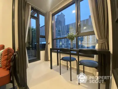 Elegant corner unit with expansive windows offering a serene city view, complemented by modern furnishings and a cozy balcony.