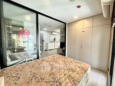 Modern bedroom with sliding glass doors and built-in wardrobe in a stylish apartment.