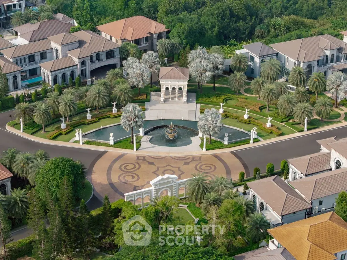 Luxurious aerial view of a grand estate with elegant landscaping and fountain centerpiece.