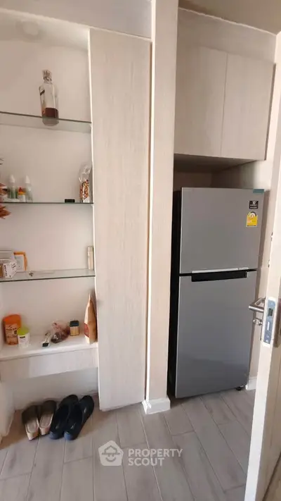 Modern kitchen with sleek fridge and open shelving for stylish storage solutions.