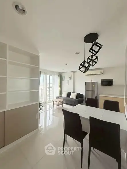 Modern open-plan living room with dining area and balcony view in a stylish apartment.