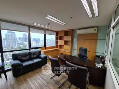 Modern office space with city view, featuring sleek furniture and ample natural light.