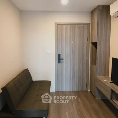 Modern apartment entrance with stylish wooden flooring and compact sofa
