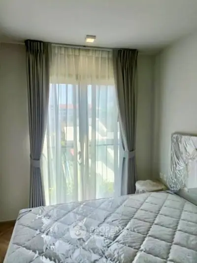 Bright bedroom with large window and modern curtains, featuring a comfortable bed and serene ambiance.