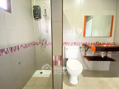 Modern bathroom with shower and stylish sink in a real estate property.