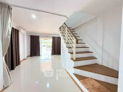 Spacious modern living room with staircase and large windows for natural light.