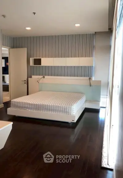 Modern bedroom with sleek design and dark wood flooring