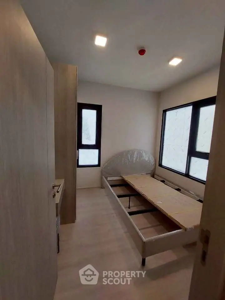 Cozy bedroom with natural light and modern minimalist design, perfect for relaxation and comfort.