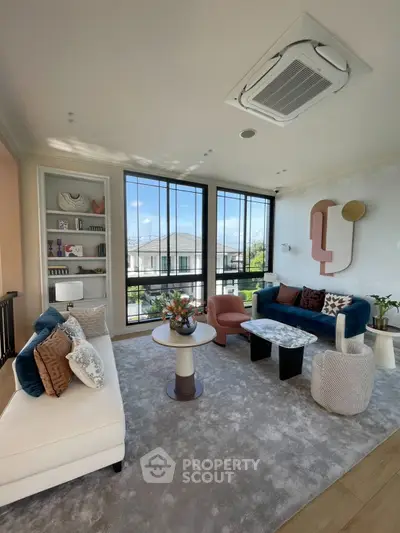 Luxurious modern living room with stylish furniture and large windows offering a scenic view.