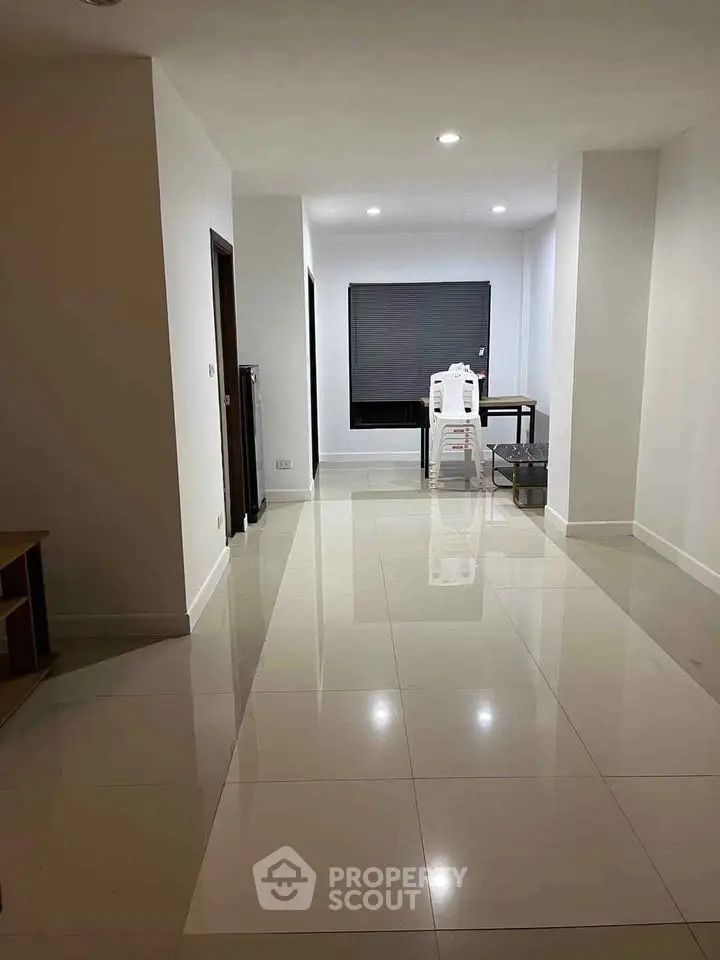 Spacious modern living area with glossy tiled floors and minimalist decor.