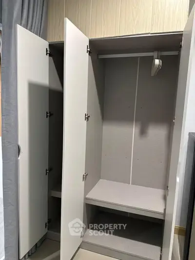 Spacious modern wardrobe with open doors showcasing ample storage space.