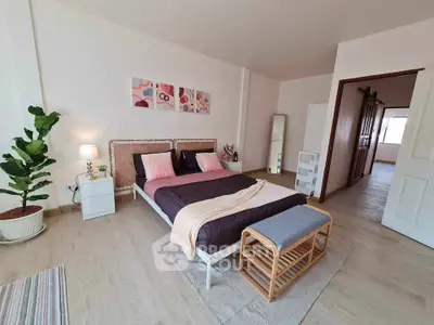 Spacious bedroom with modern decor and natural light, featuring a cozy bed and stylish furnishings.