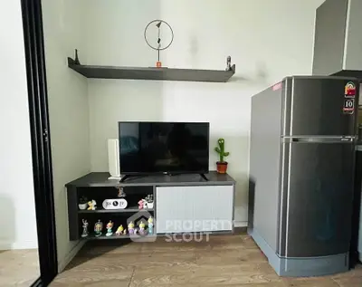 Modern living room with sleek TV stand and stainless steel fridge, perfect for compact urban living.