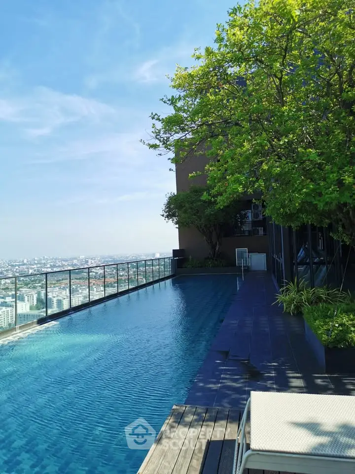 Luxurious rooftop pool with stunning city view and lush greenery, perfect for relaxation and leisure.