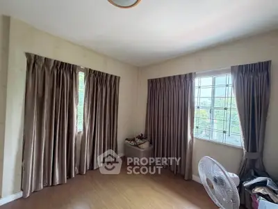 Spacious room with large windows and elegant curtains, perfect for natural light and comfort.