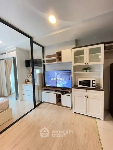Modern studio apartment with open layout and stylish kitchen cabinetry.