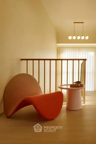 Stylish modern interior with unique orange chair and elegant lighting, perfect for contemporary living spaces.