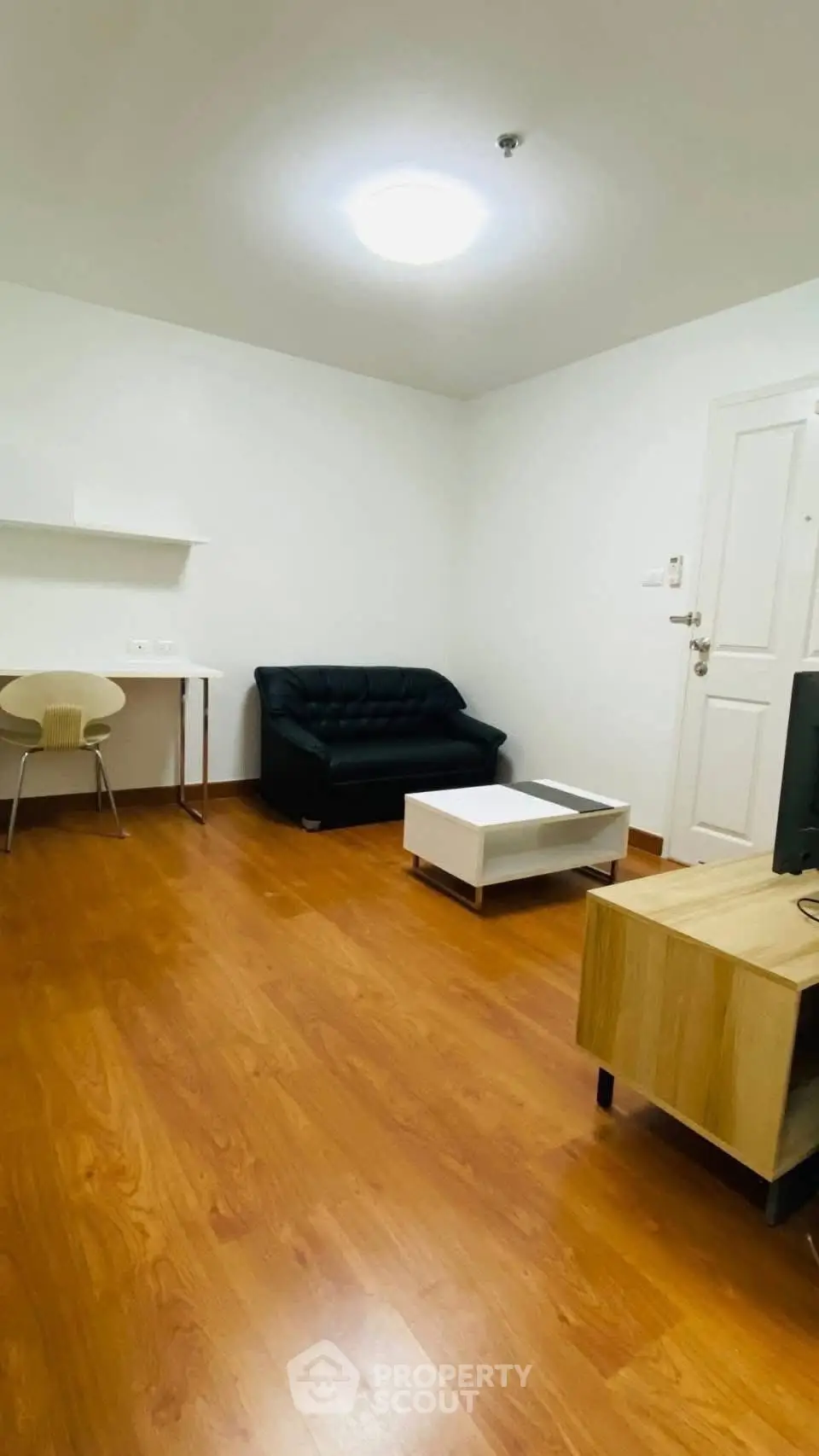Cozy living room with wooden flooring, modern furniture, and bright lighting.