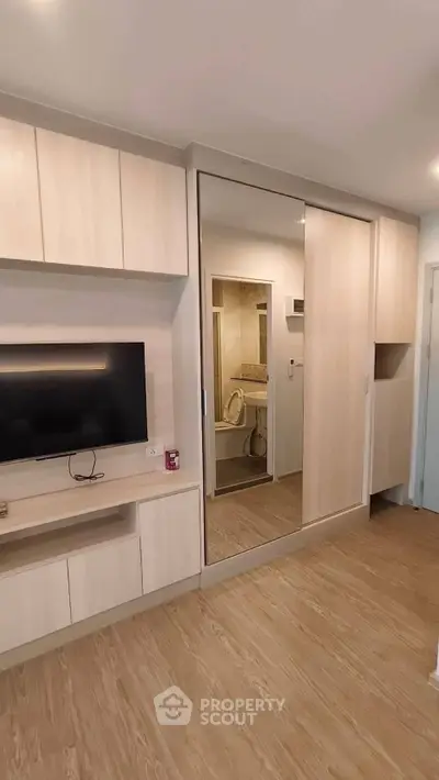 Modern bedroom with mirrored wardrobe and sleek TV unit