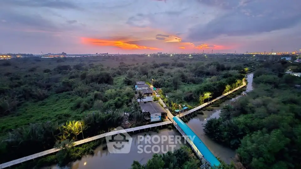 Stunning aerial view of lush greenery and serene waterway at sunset, perfect for tranquil living.