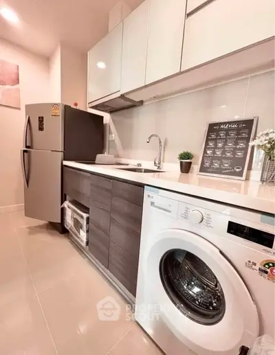 Modern kitchen with sleek appliances and stylish cabinetry in a contemporary apartment.