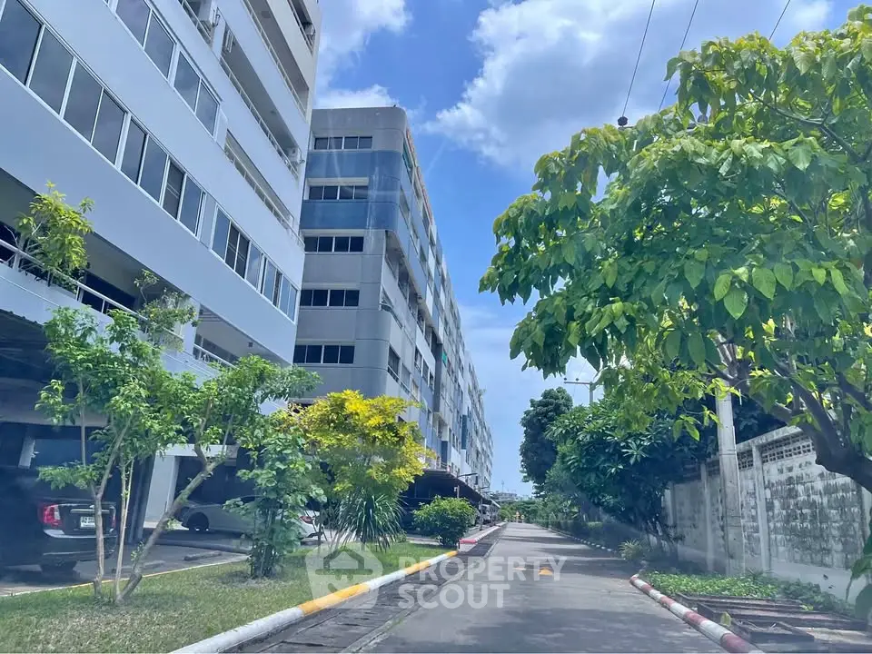 Modern residential building with lush greenery and clear blue sky