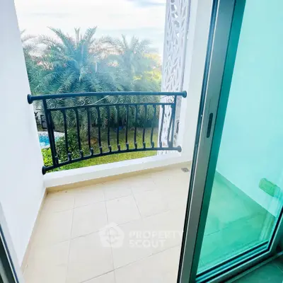 Charming balcony with garden view and glass sliding door in modern home.