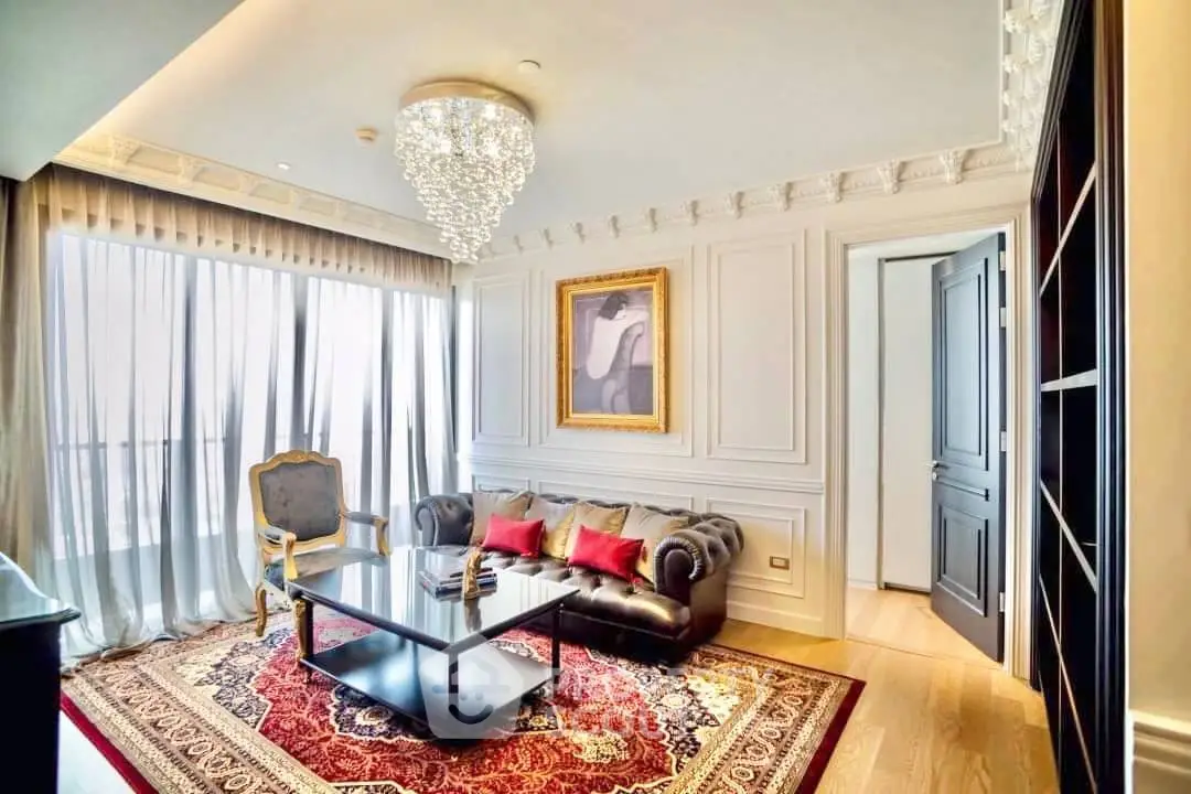 Luxurious living room with elegant chandelier and classic decor, featuring a plush sofa and large windows.