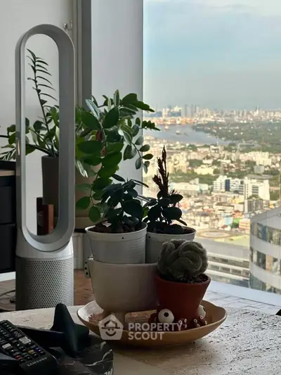 Stylish interior with plants and city view from high-rise apartment window.