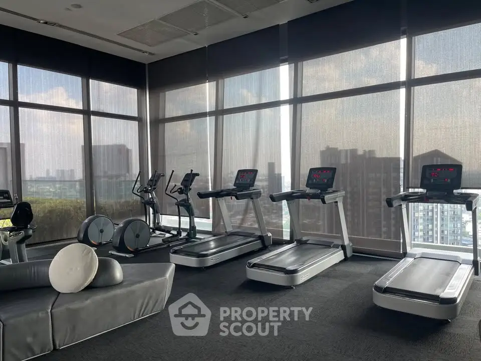 Luxurious high-rise gym with panoramic city views and modern fitness equipment.