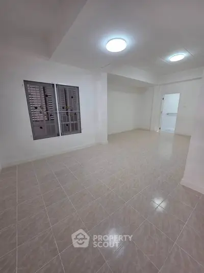 Spacious unfurnished room with tiled flooring and ample natural light, perfect for customization.