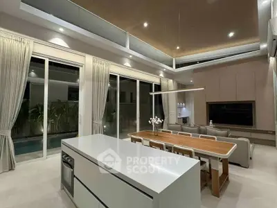 Luxurious open-plan kitchen and living area with modern design and pool view.