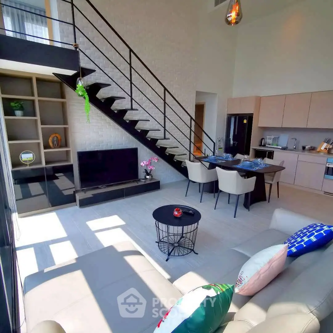 Modern open-plan living room with stylish kitchen and loft staircase