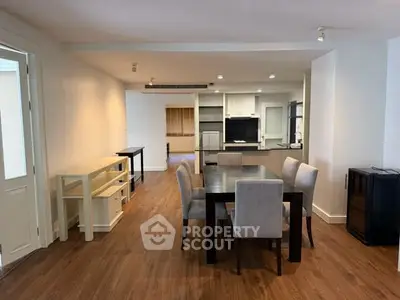 Spacious dining area with modern furniture and open kitchen layout in a stylish apartment.