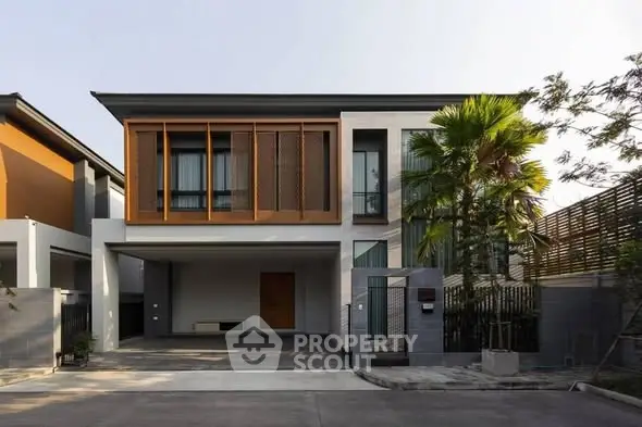 Modern two-story house with sleek design and spacious driveway, featuring large windows and contemporary facade.