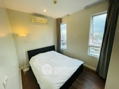 Cozy bedroom with city view, featuring a comfortable bed and modern decor, perfect for relaxation.