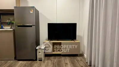 Modern living space with sleek fridge and TV setup, perfect for urban living.