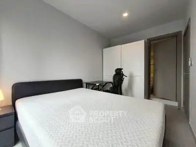 Modern bedroom with minimalist design featuring a comfortable bed and sleek furniture.