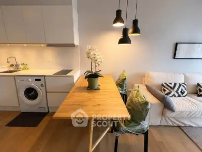 Modern open-plan kitchen and living area with stylish lighting and cozy seating.