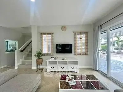 Spacious modern living room with stylish decor and large windows offering natural light.