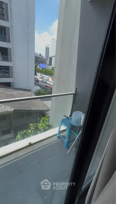 Urban balcony view with cityscape and clear blue sky, perfect for city living enthusiasts.