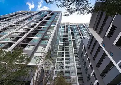 Modern high-rise residential building with sleek architecture and large windows.