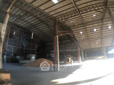 Spacious industrial warehouse with high ceilings and ample natural light, ideal for storage or manufacturing.