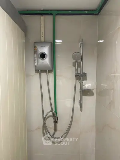 Compact bathroom shower area with modern water heater and sleek fixtures.