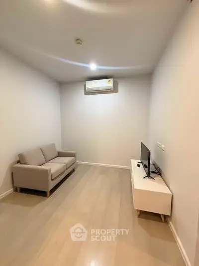 Cozy minimalist living room with sofa and TV, perfect for relaxation.