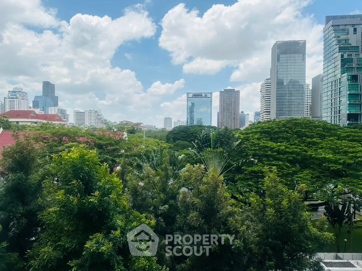 Stunning cityscape view with lush greenery and modern skyscrapers under a bright blue sky.