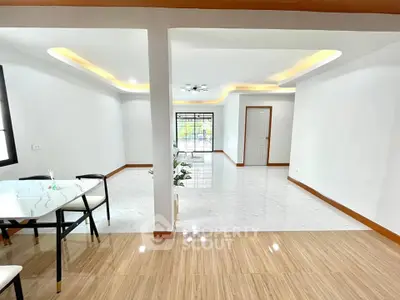 Spacious modern living room with elegant dining area and stylish ceiling lights.