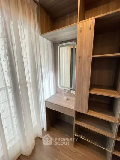 Elegant wooden storage unit with built-in vanity near sheer curtained window